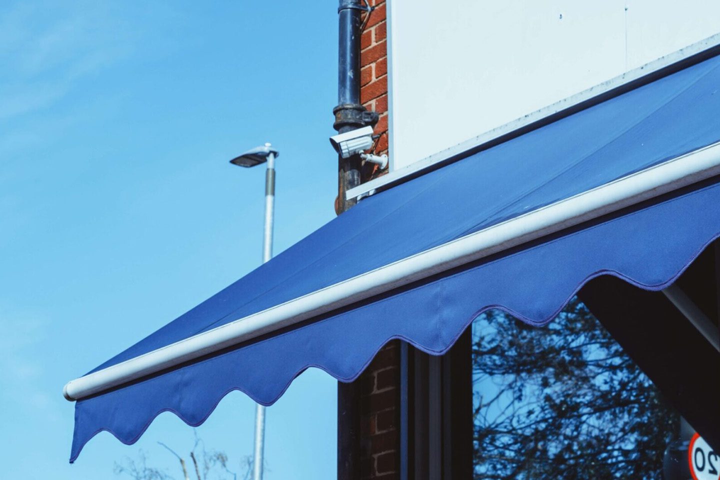 A blue awning is shown on the side of a building.